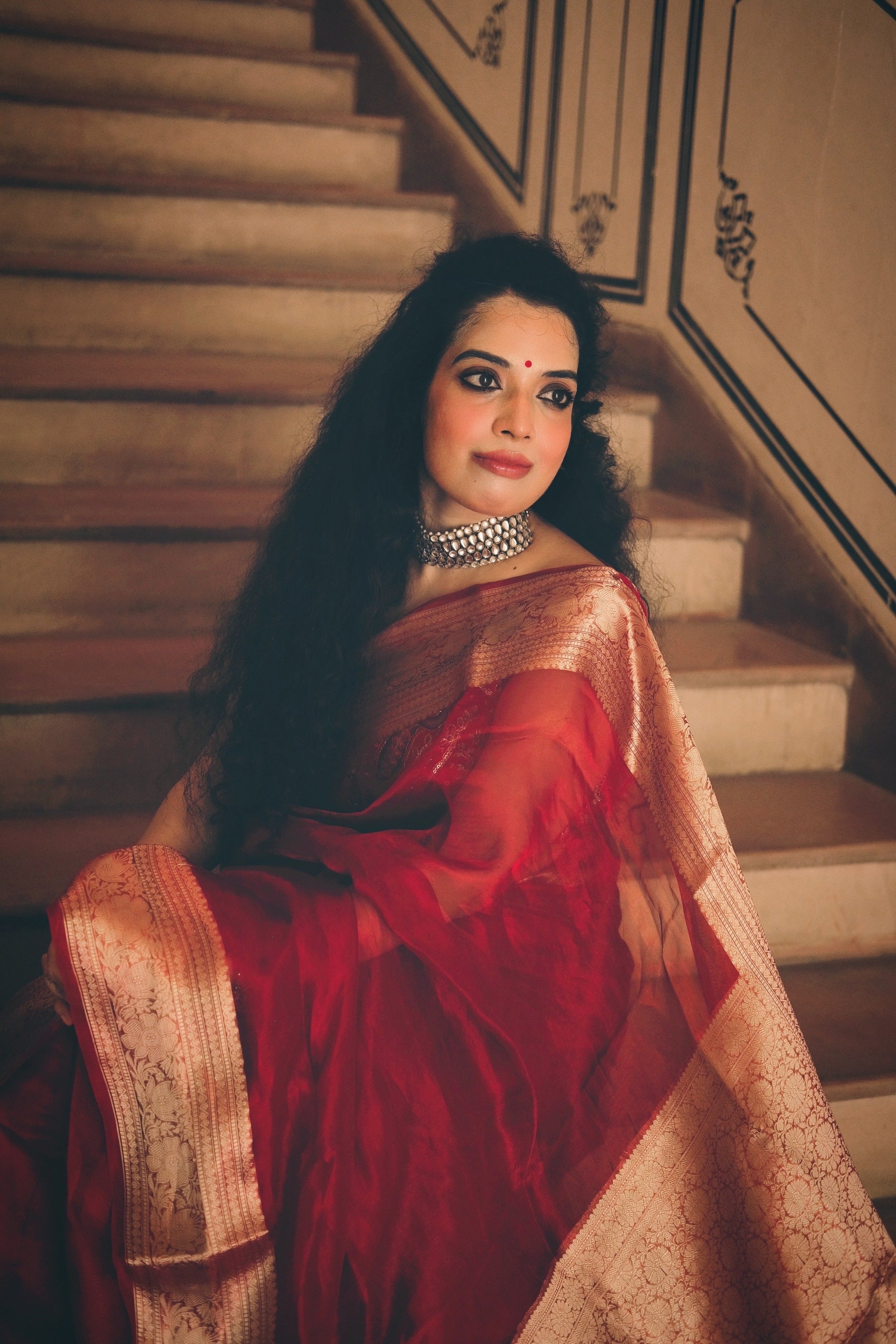Handwoven carmine red Banarasi silk saree with gold zari, sourced directly from weavers in Banaras.