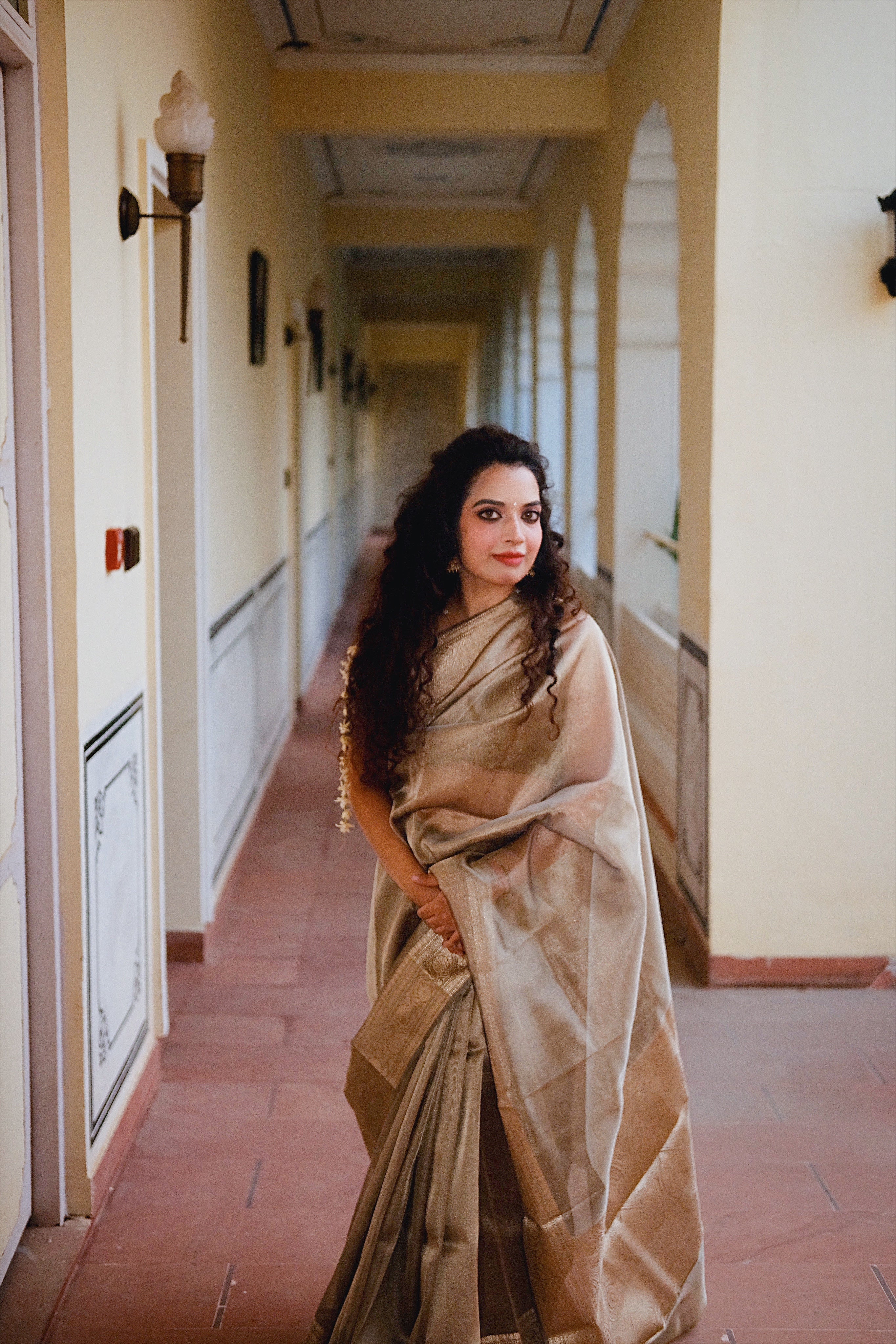 Aparajita Kansya antique gold bronze tissue silk saree, styled lifestyle portrait